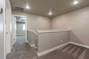 Corridor with carpet and a textured ceiling