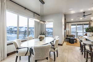 Dining space with ceiling fan, light hardwood / wood-style floors, and a mountain view