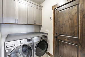 Laundry room featuring washer and dryer and cabinets