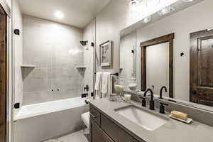 Bathroom featuring tile patterned floors, vanity, and tiled shower / bath combo