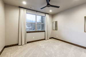 Empty room with light carpet and ceiling fan