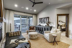 Living room featuring ceiling fan, light hardwood / wood-style floors, and lofted ceiling