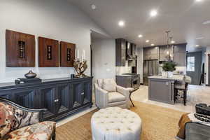 Living room with light hardwood / wood-style floors and lofted ceiling