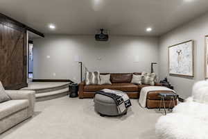 Living room with a barn door and light carpet