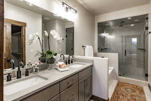 Bathroom featuring tile patterned floors, vanity, and separate shower and tub