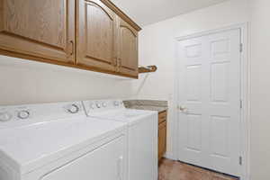 Laundry room featuring cabinets and washing and dryer