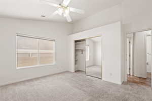 Master bedroom featuring light carpet, a closet, ceiling fan, and lofted ceiling with plant shelves