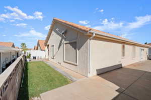 View of property exterior with a patio area and a yard