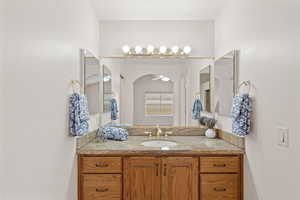 Master bathroom with vanity and ceiling fan