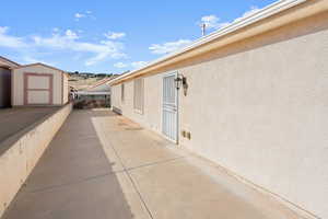 View of home's exterior featuring a patio area and a storage unit