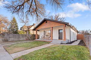 View of front of house with covered porch and a front yard