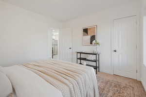 Carpeted bedroom with stainless steel fridge