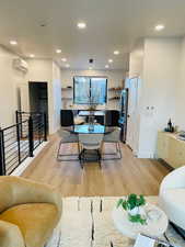 Dining space featuring light hardwood / wood-style flooring and a wall unit AC