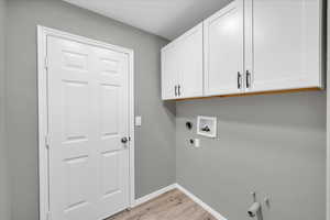 Laundry area with hookup for an electric dryer, hookup for a washing machine, gas dryer hookup, and cabinets