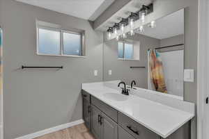 Bathroom featuring hardwood / wood-style floors, vanity, and a textured ceiling