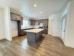 Kitchen with a center island, light wood-type flooring, sink, and appliances with stainless steel finishes