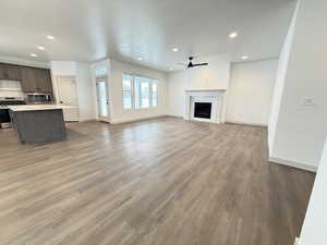 Unfurnished living room featuring hardwood / wood-style floors and ceiling fan