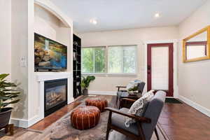 Living room with a fireplace and dark hardwood / wood-style floors