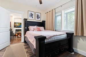 Bedroom with ceiling fan and dark wood-type flooring