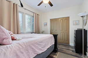 Bedroom featuring a closet, ceiling fan, and dark wood-type flooring