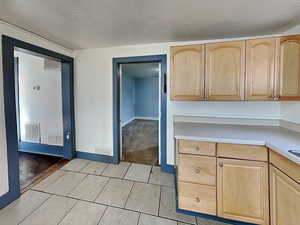 Kitchen with light brown cabinets and light tile patterned floors