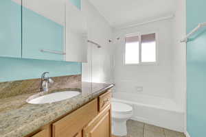 Full bathroom featuring toilet, bathtub / shower combination, vanity, and tile patterned floors