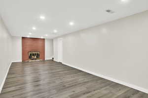 Unfurnished living room with a fireplace and wood-type flooring