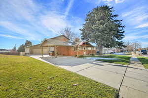 View of front of property with a front yard and a garage