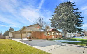 View of front of house with a 30x30 detached  garage, a front yard, and a carport