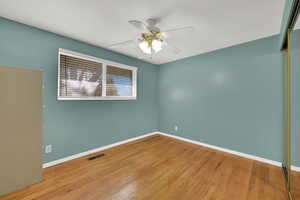 Spare room with hardwood / wood-style flooring and ceiling fan