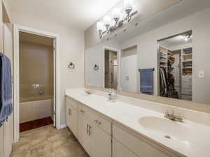 Bathroom featuring vanity and a relaxing tiled tub