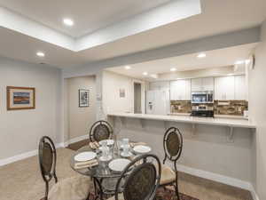 Dining space featuring light carpet and sink