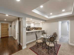 Dining space featuring hardwood / wood-style floors and a tray ceiling