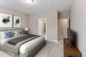 Bedroom with light colored carpet and a textured ceiling