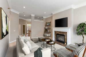 Living room with a high end fireplace and ornamental molding