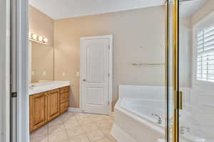 Bathroom with shower with separate bathtub, vanity, and tile patterned floors