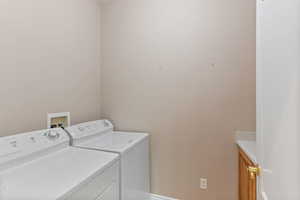 Clothes washing area with washer and clothes dryer and cabinets