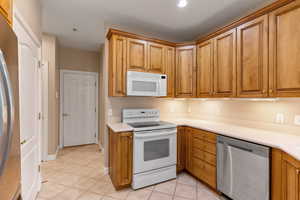 Kitchen with light tile patterned floors and appliances with stainless steel finishes