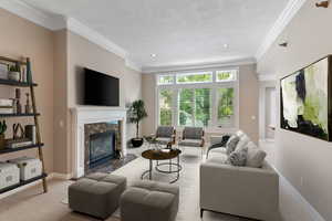 Living room featuring light carpet, a high end fireplace, a textured ceiling, and ornamental molding