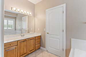 Bathroom with vanity, tile patterned floors, and a tub