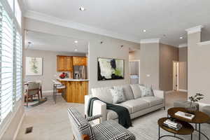 Carpeted living room with washer / dryer and ornamental molding