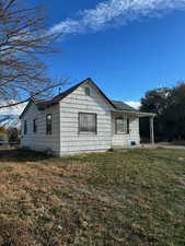 View of home's exterior featuring a porch and a lawn