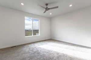 Carpeted spare room with ceiling fan