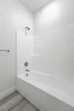 Bathroom featuring shower / washtub combination and hardwood / wood-style flooring