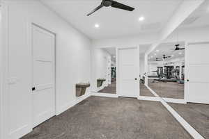 Workout area with ceiling fan and carpet floors