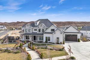 View of front of property featuring a mountain view, a garage, and a front yard