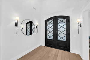 Entrance foyer with french doors and light hardwood / wood-style flooring