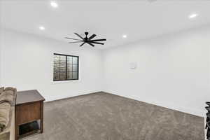 Carpeted empty room featuring ceiling fan