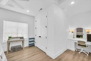 Home office featuring ceiling fan and light hardwood / wood-style flooring