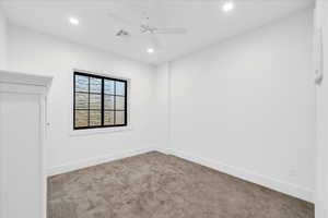 Carpeted empty room featuring ceiling fan